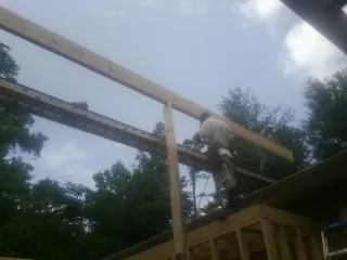 Carpenter setting a ridge beam over a new addition frame — Ice Dam Removal by Roofing Brothers in Hathorne