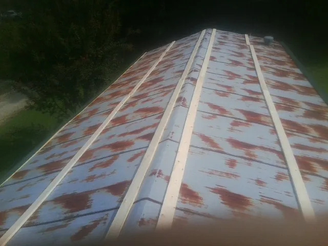Rusted metal roof panels with new wood purlins before replacement — Storm Damage Roof Repair in Hathorne by Roofing Brothers