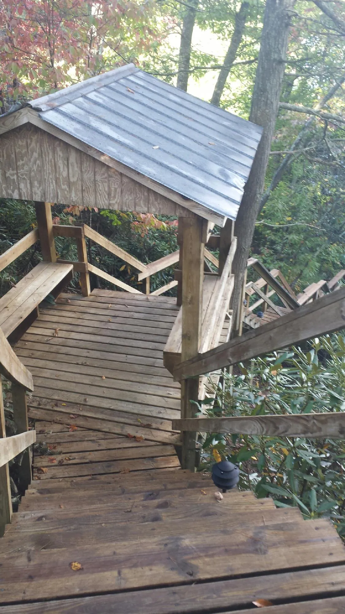 Metal roofed shelter over wooden steps on a wooded walkway — Skylight Repair & Installation work by our crew in Hathorne