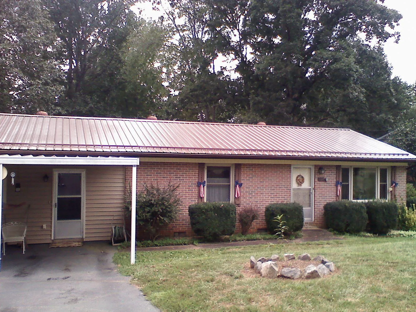Bronze metal roof and carport on a brick ranch home — Roof Repair work by our crew in Hathorne